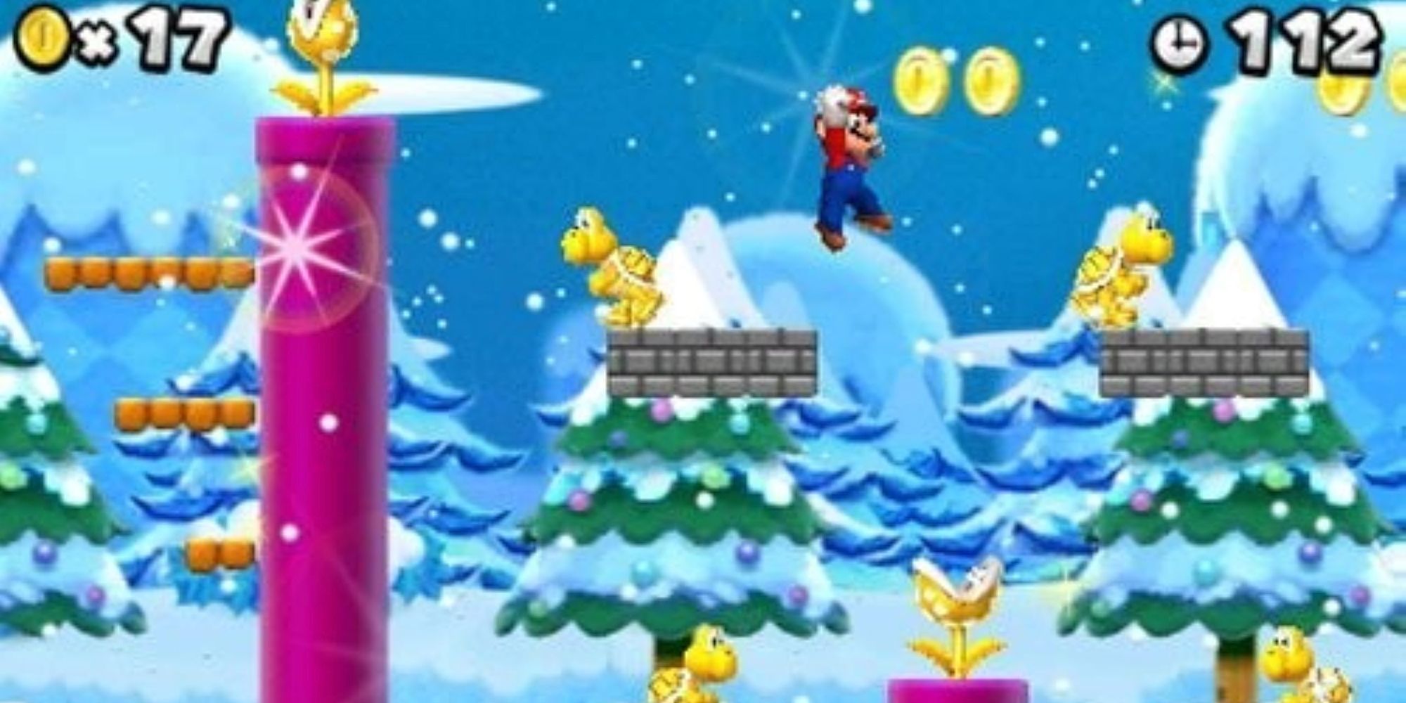 Mario sautant par-dessus des ennemis en or dans un niveau enneigé