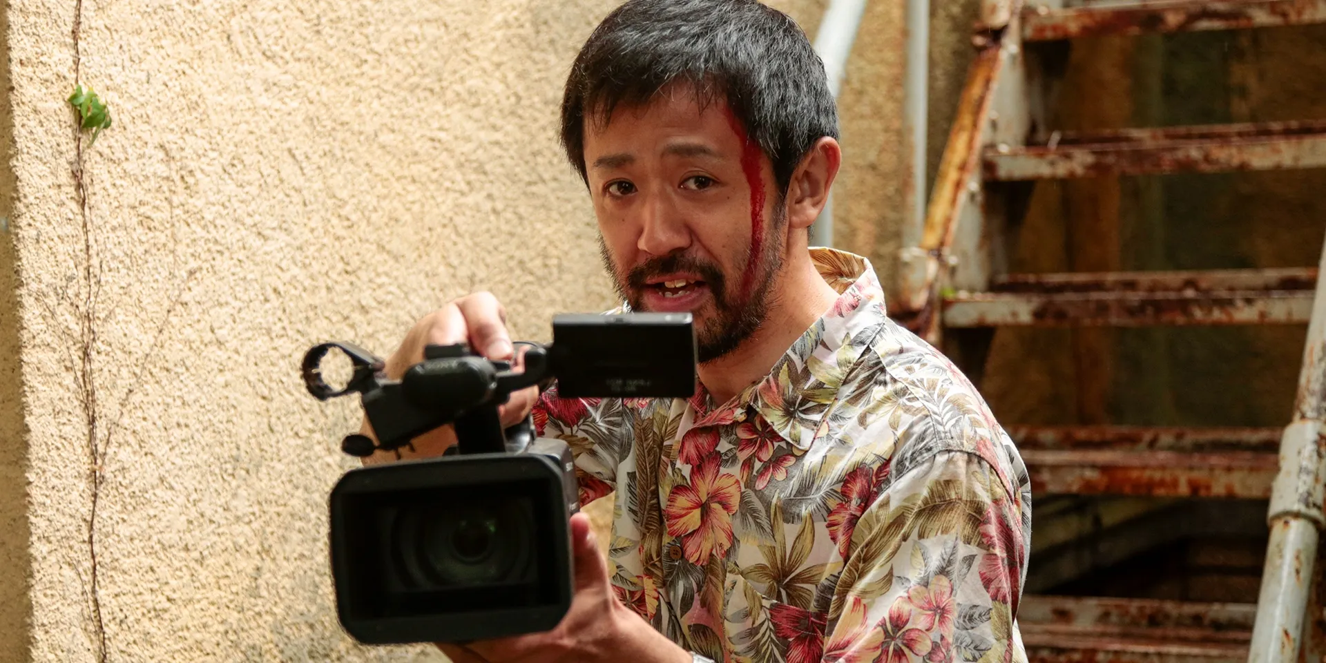 The director films while standing next to a stairway in a scene from ‘One Cut of the Dead’