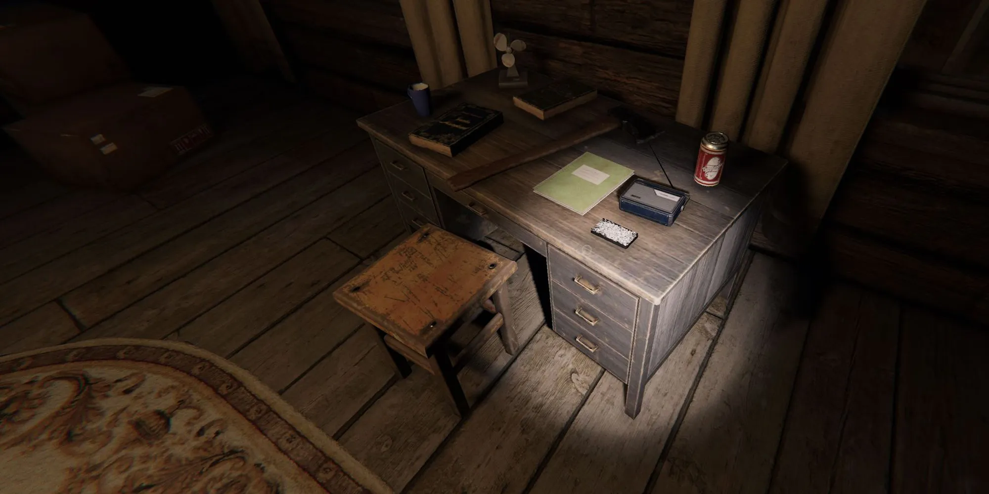 L'image représente une lampe de poche pointant vers un petit bureau en bois à la ferme de Bleasdale dans Phasmophobia.