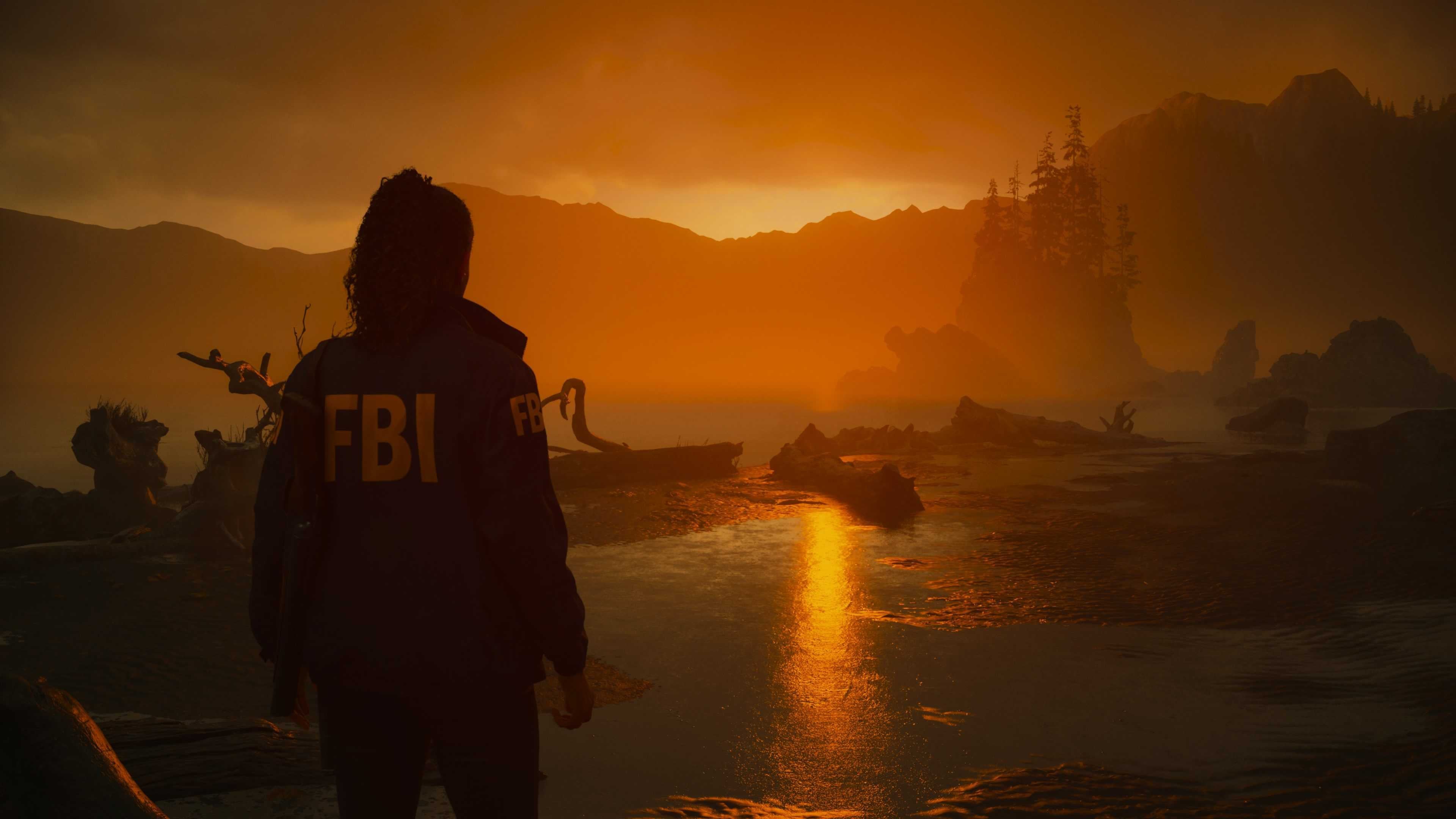 Saga Anderson guarda il Lago Caldera al tramonto in Alan Wake 2. Indossa una giacca dell'FBI e ha i capelli raccolti in una coda di cavallo.