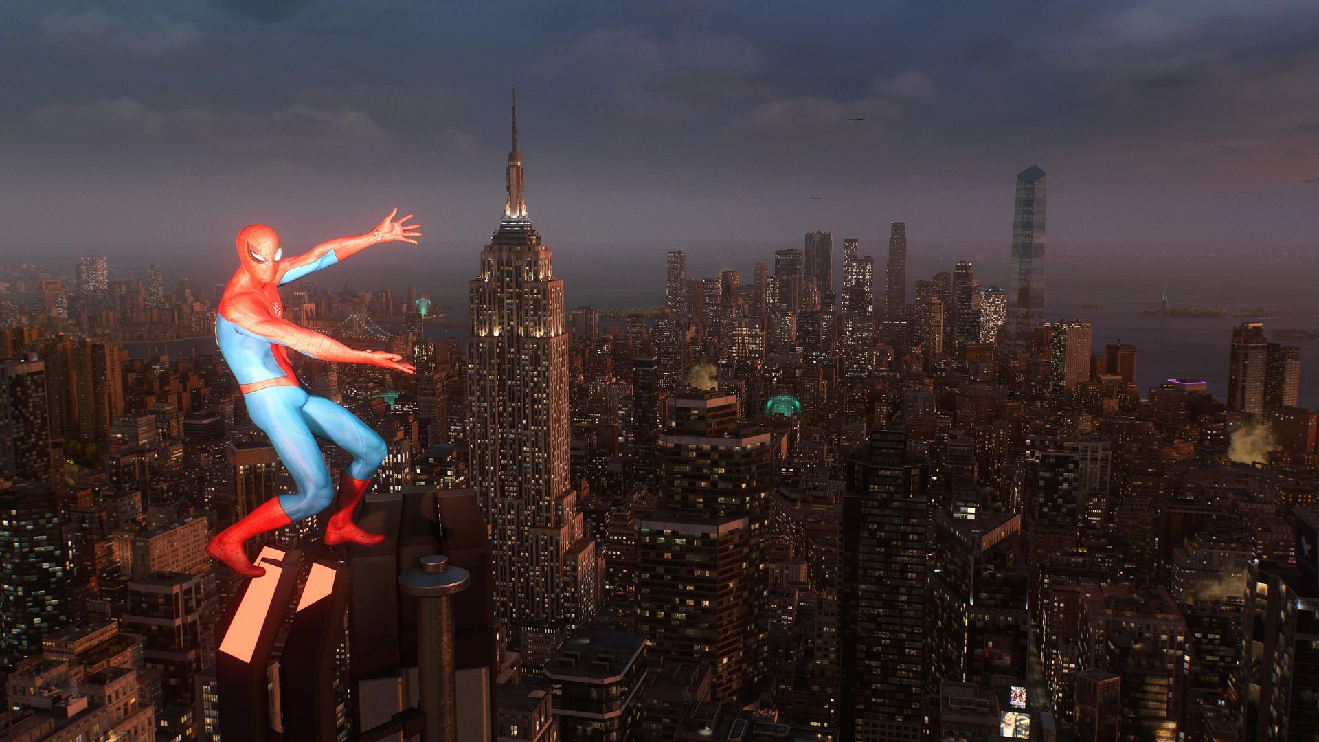 Image : Spider-Man se tient au sommet d'un gratte-ciel, bras écartés, offrant une vue sur la ville de New York au crépuscule. Spider-Man 2 est un magnifique jeu !