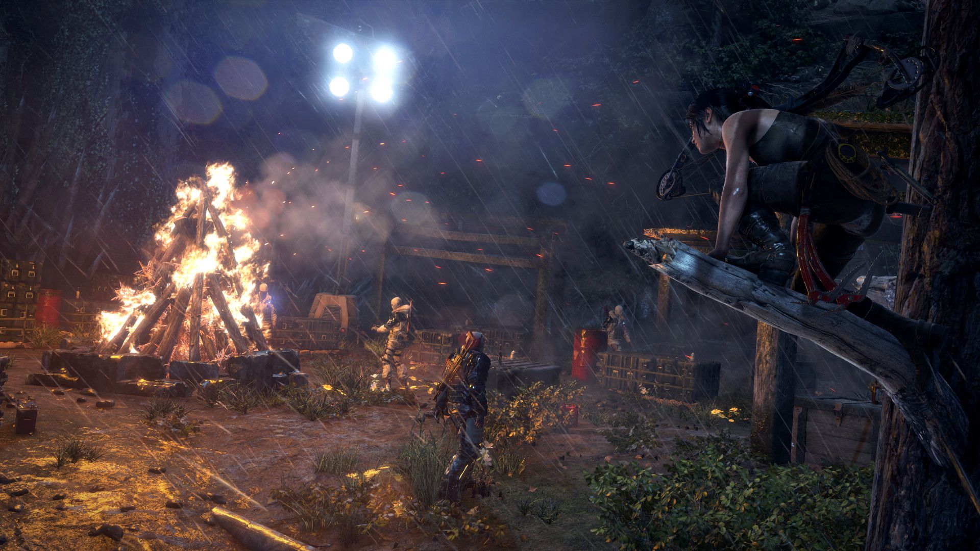 Lara Croft posada en una rama de un árbol observando un campamento enemigo en Rise of the Tomb Raider.