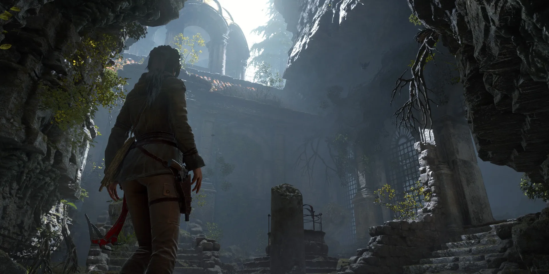 Lara Croft mirando hacia arriba a las ruinas dentro de una alcoba