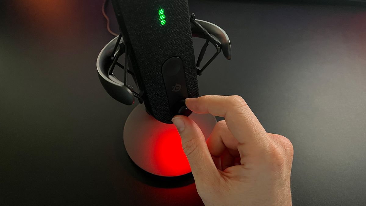SteelSeries Alias review image showing the reviewer turning one of the microphone’s dials.