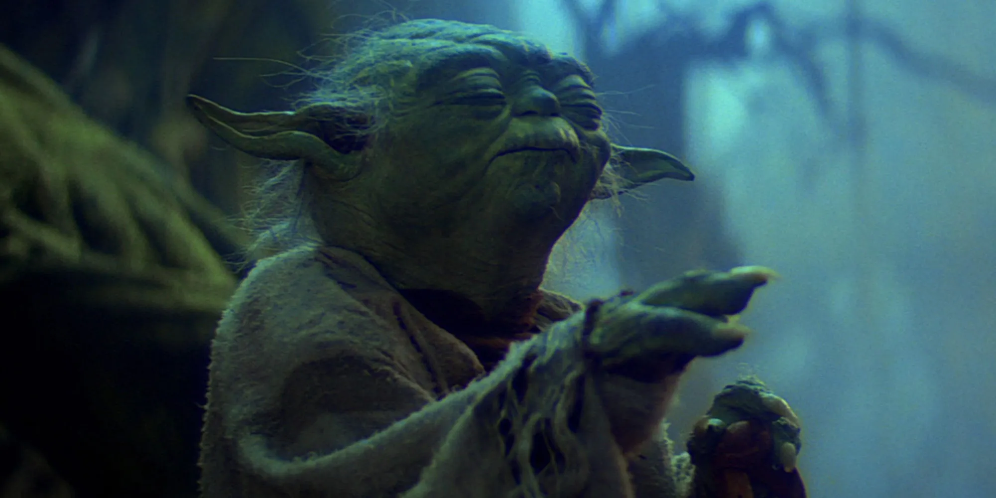 Yoda with his hand raised and eyes closed as he lifts Luke’s X-Wing out of the swamp