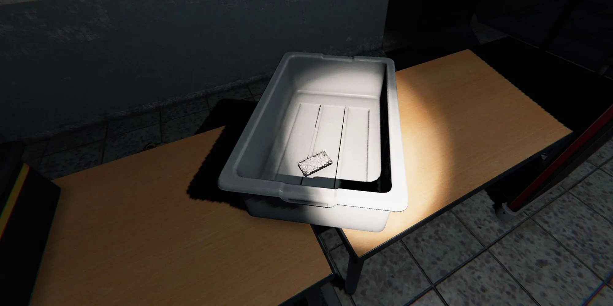 图片展示了Phasmophobia中监狱的木桌上放着一个装有塔罗牌的灰色塑料盒子。