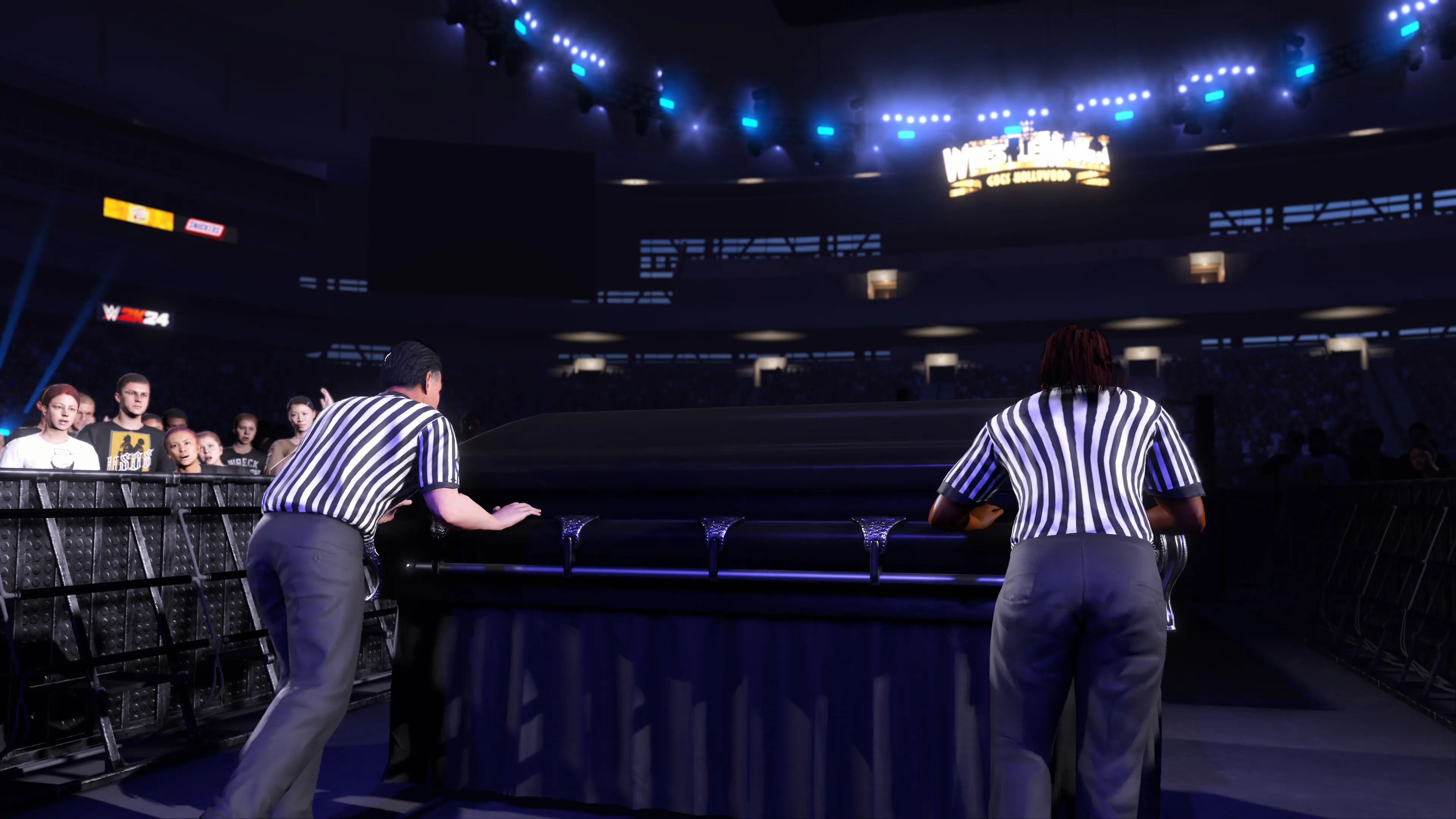 两名裁判在WWE 2K24的棺材比赛前将棺材推向擂台。