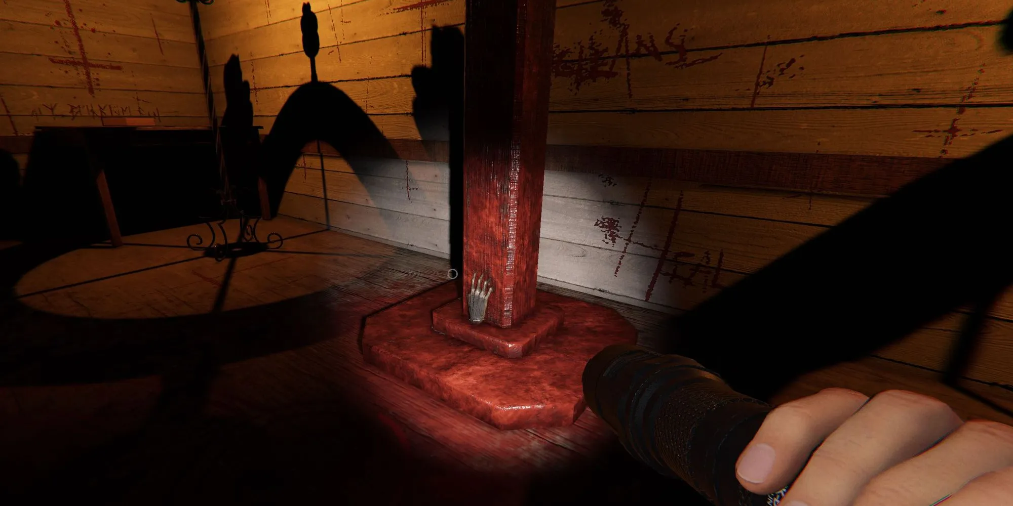 Image depicts a monkey paw on a red metal pillar in the Chapel of Sunny Meadows in Phasmophobia.