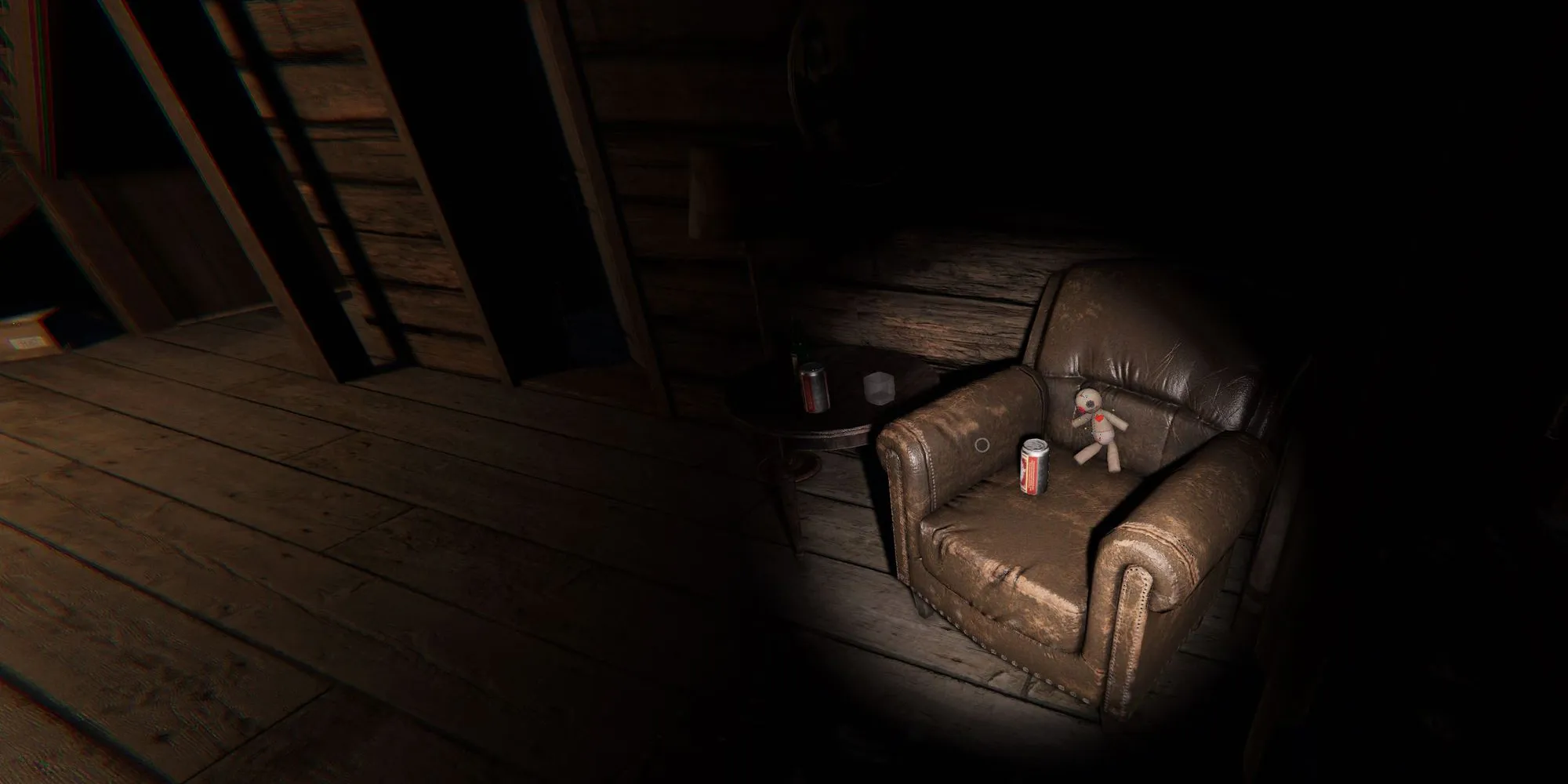 图像显示了幽灵惊魂中Bleasdale农舍的二楼，与阁楼楼梯旁边的两间卧室对面的棕色皮革椅上坐着一只小巫毒娃娃。