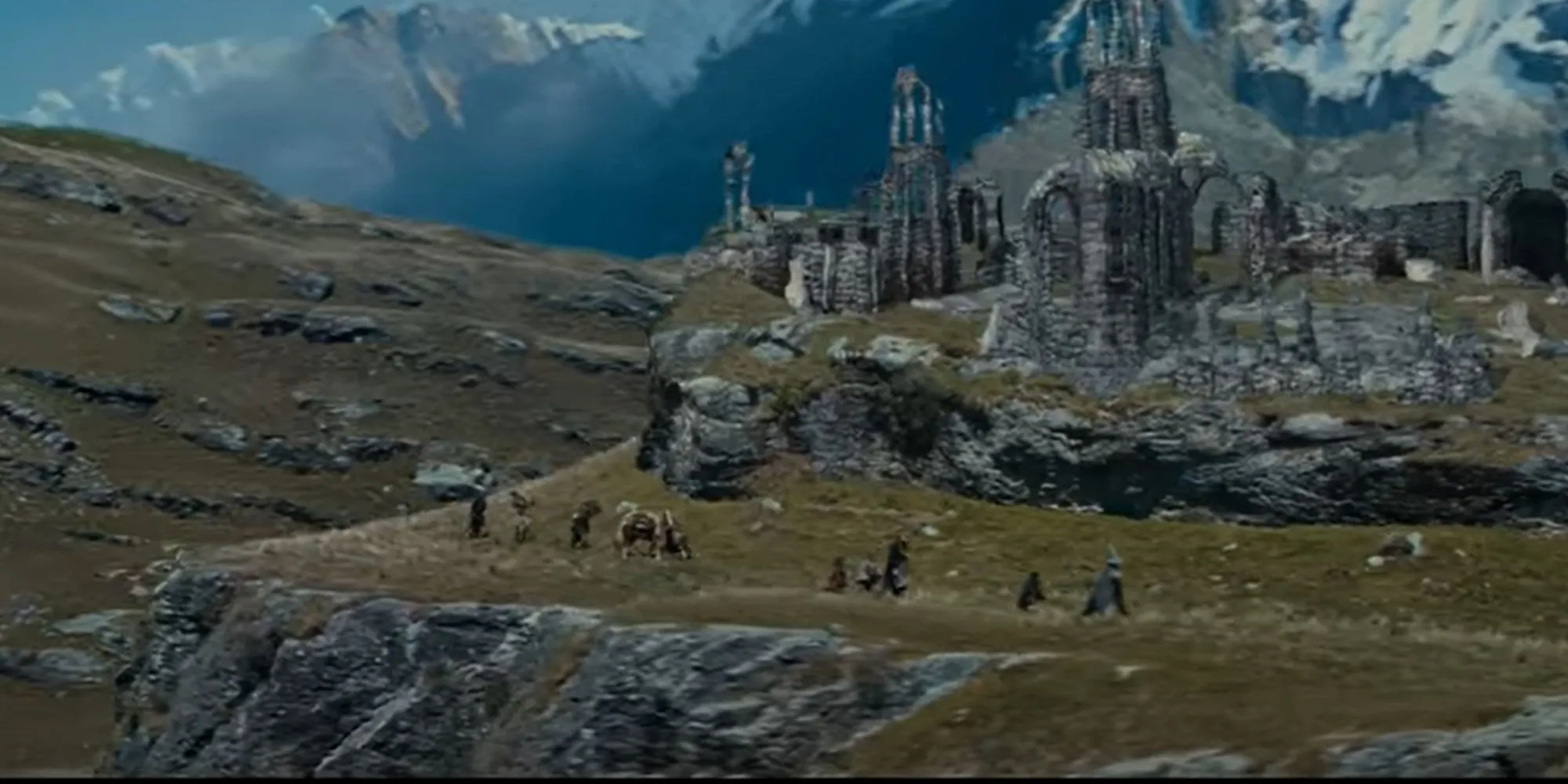 The Fellowship of the Ring が列をなして遺跡のそばを歩いているイメージ