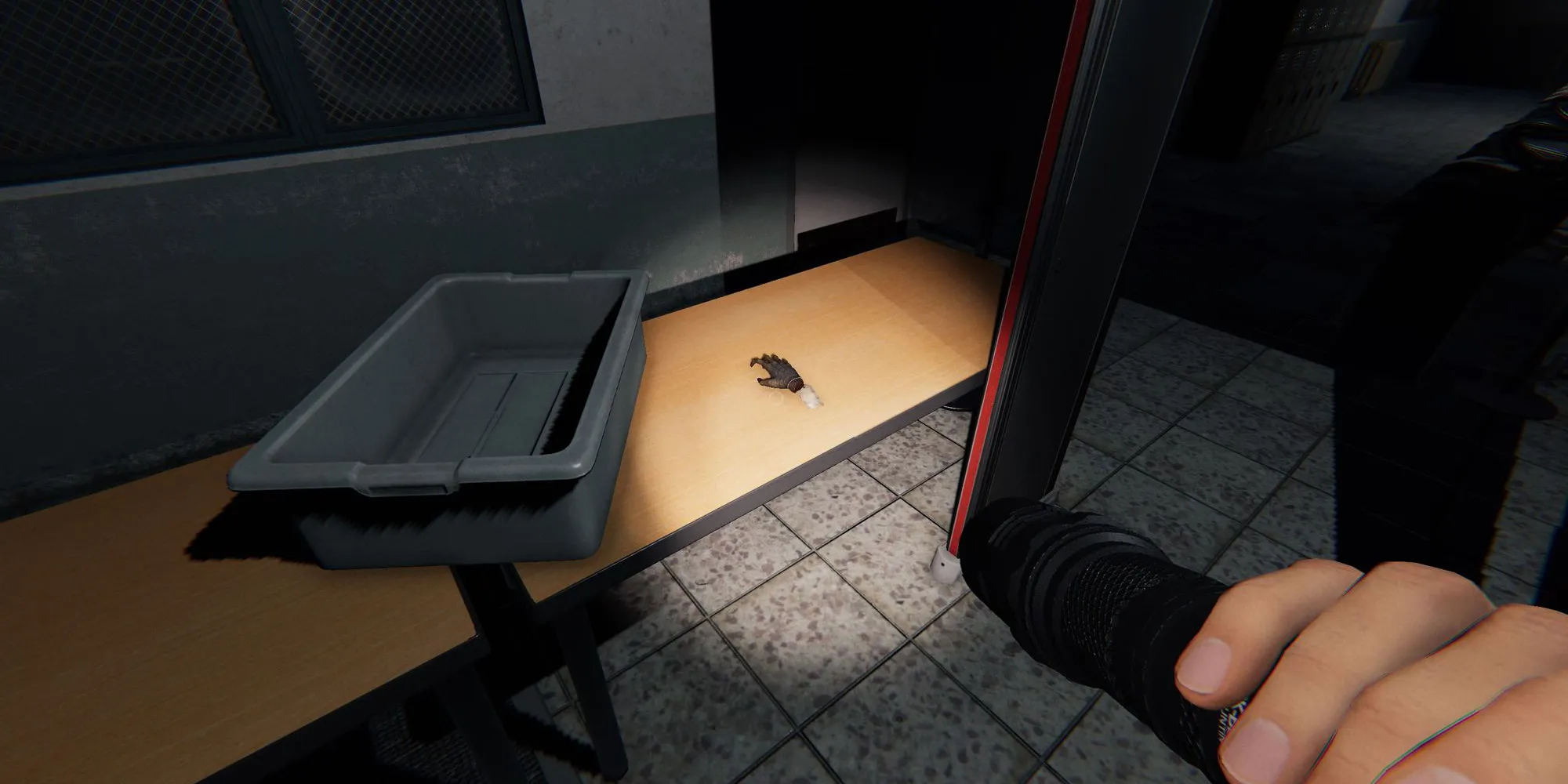Image depicts a monkey paw on a desk in the Prison in Phasmophobia.