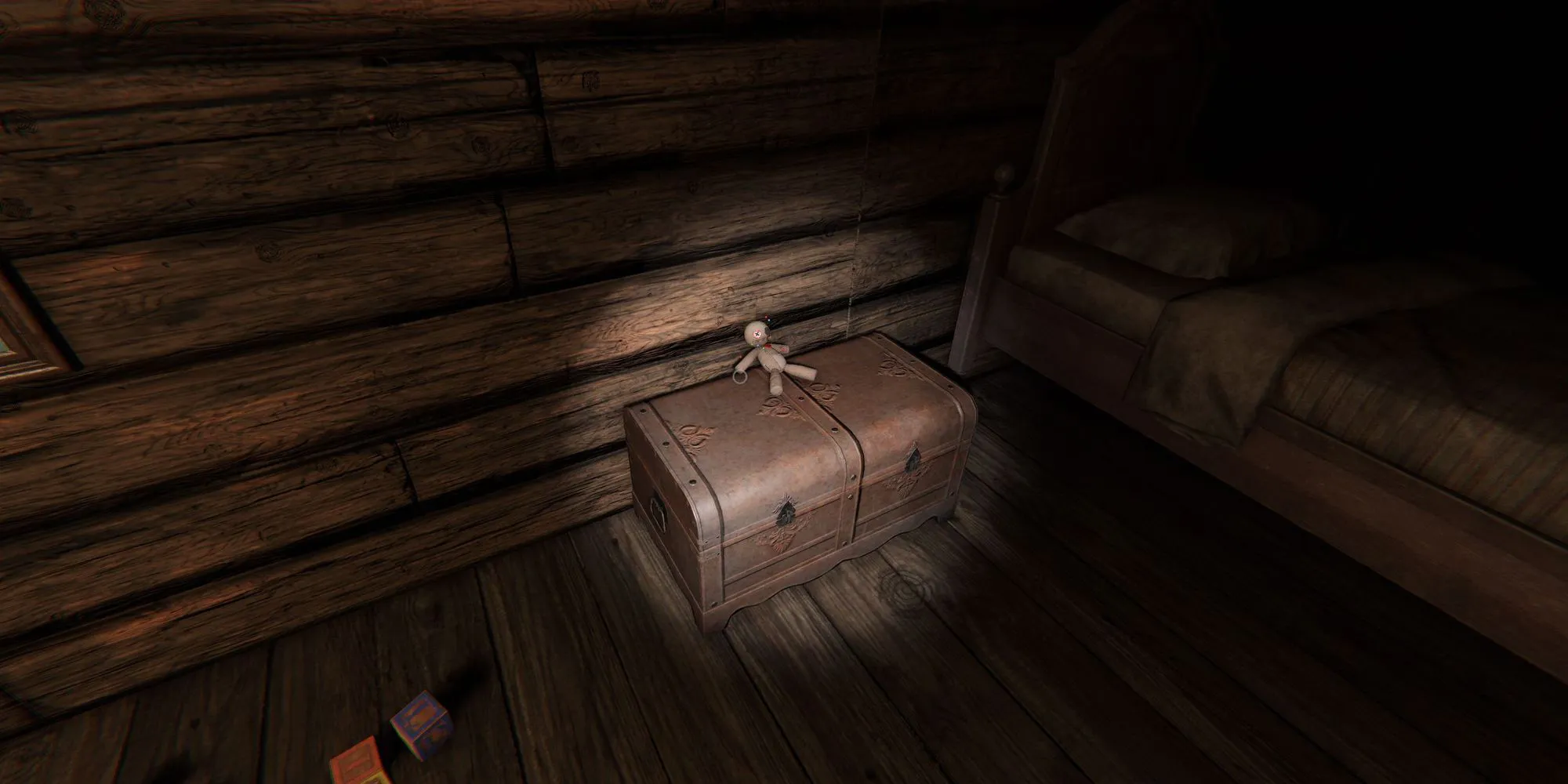 Image depicts a voodoo doll on top of a small leather chest in Grafton Farmhouse in Phasmophobia.