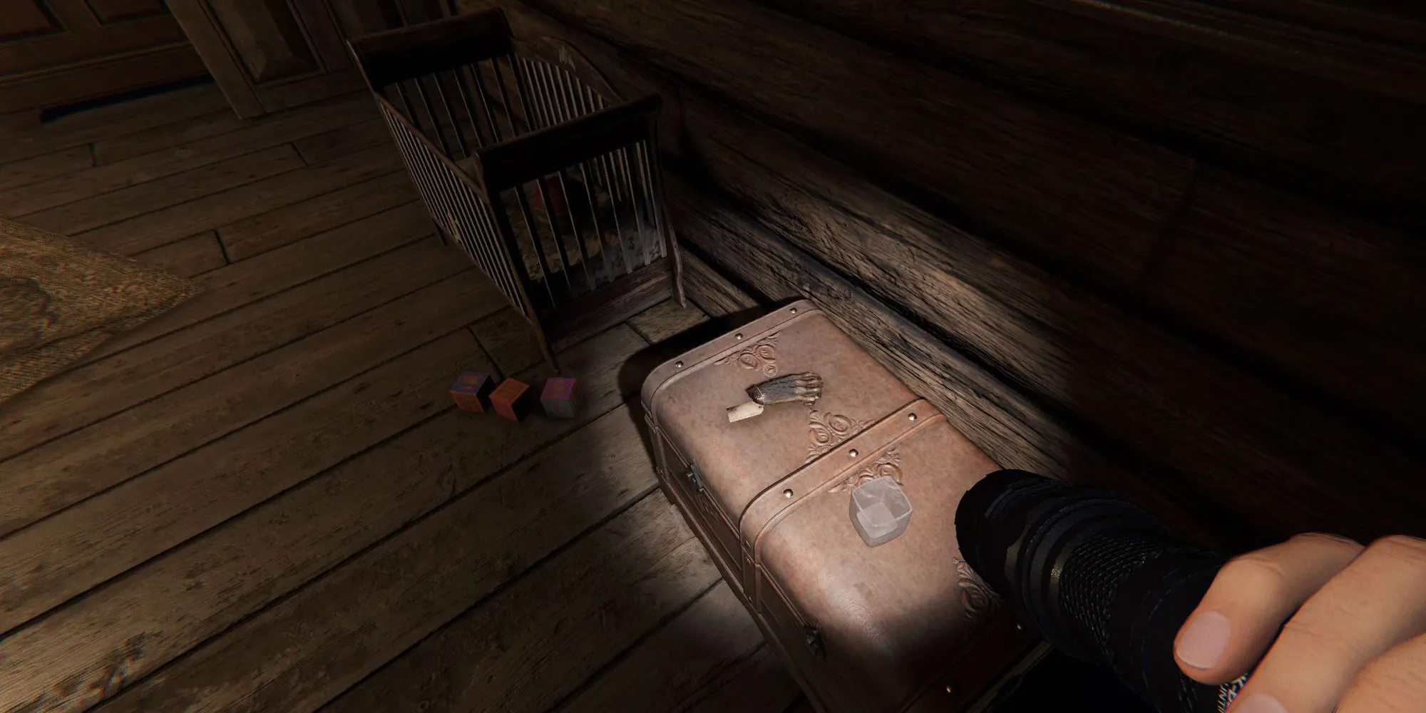 图像显示了幽灵惊魂中Bleasdale农舍的一间孩子房里放在皮革箱子上的猴爪。