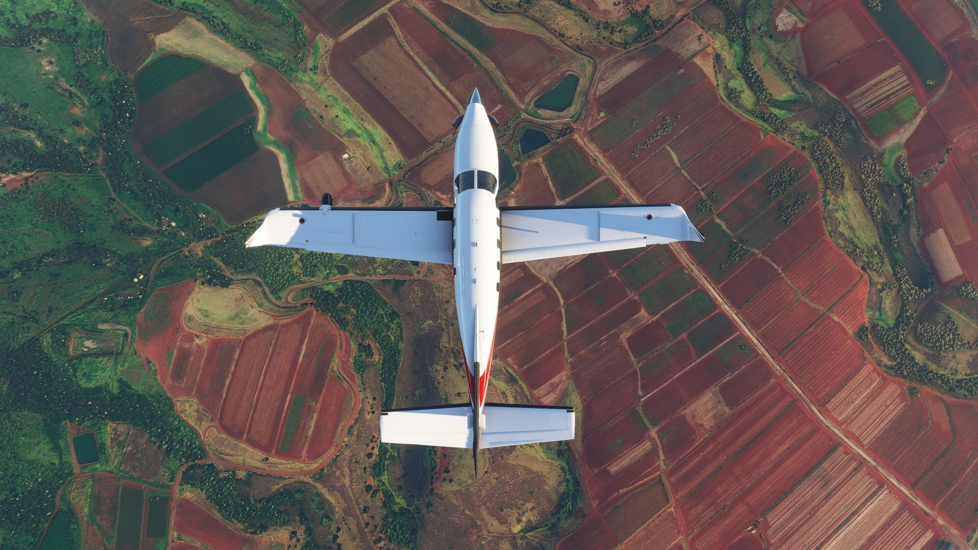 Самолет летит над полями разноцветных ферм в Microsoft Flight Simulator