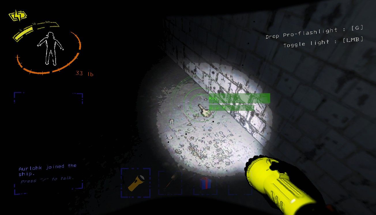 Lethal Company의 복잡한 복도에 있는 바닥에 놓인 작은 금속 열쇠 위로 플레이어 캐릭터가 프로 플래시라이트를 비춘다.