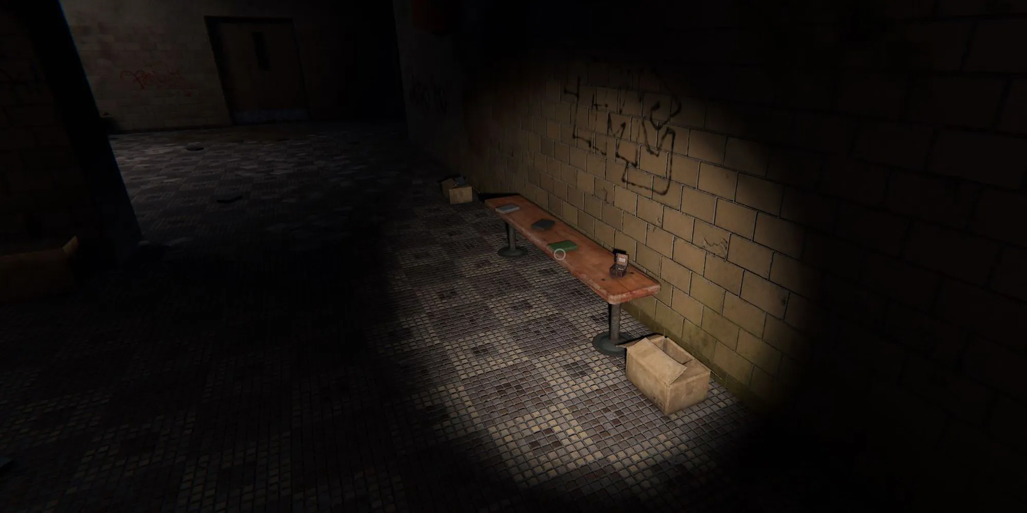 Image depicts a character in Phasmophobia pointing a flashlight at a wooden bench with a music box on top of it. Next to the bench on the floor in Brownstone High School is a cardboard box.