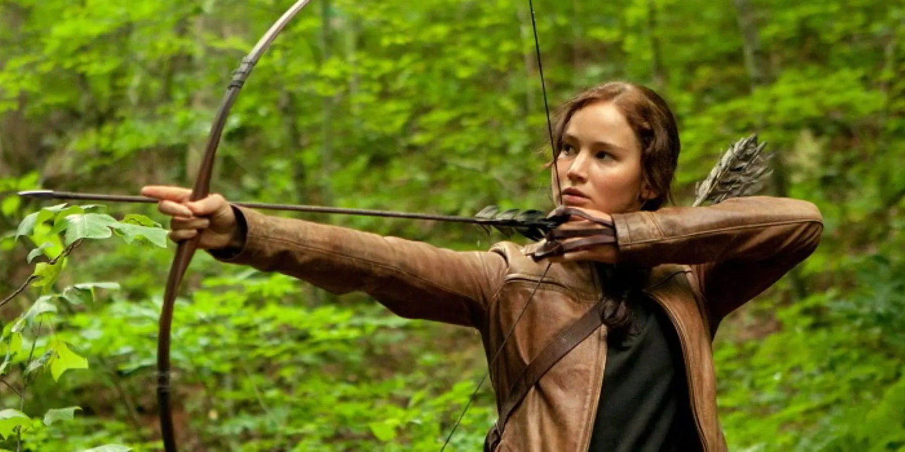 ジェニファー・ローレンスがハンガーゲームで弓を持って立つ