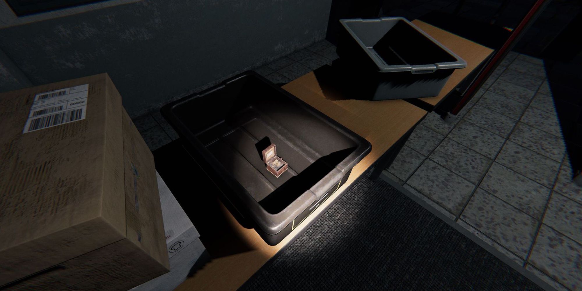 图片展示了Phasmophobia中监狱的桌子上放着一个灰色塑料盒子，里面有一个音乐盒。
