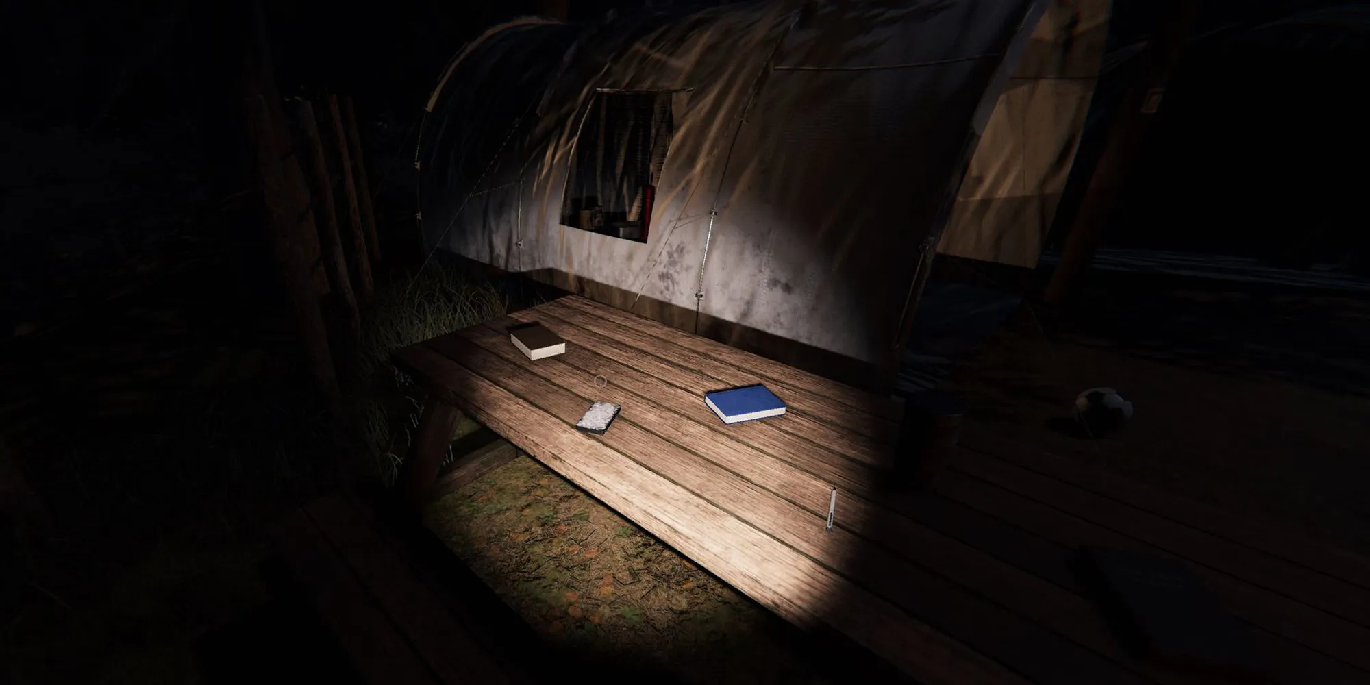 Image depicts a pack of tarot cards on a wooden picnic bench next to some blue books. This image is on Camp Woodwind in Phasmophobia.