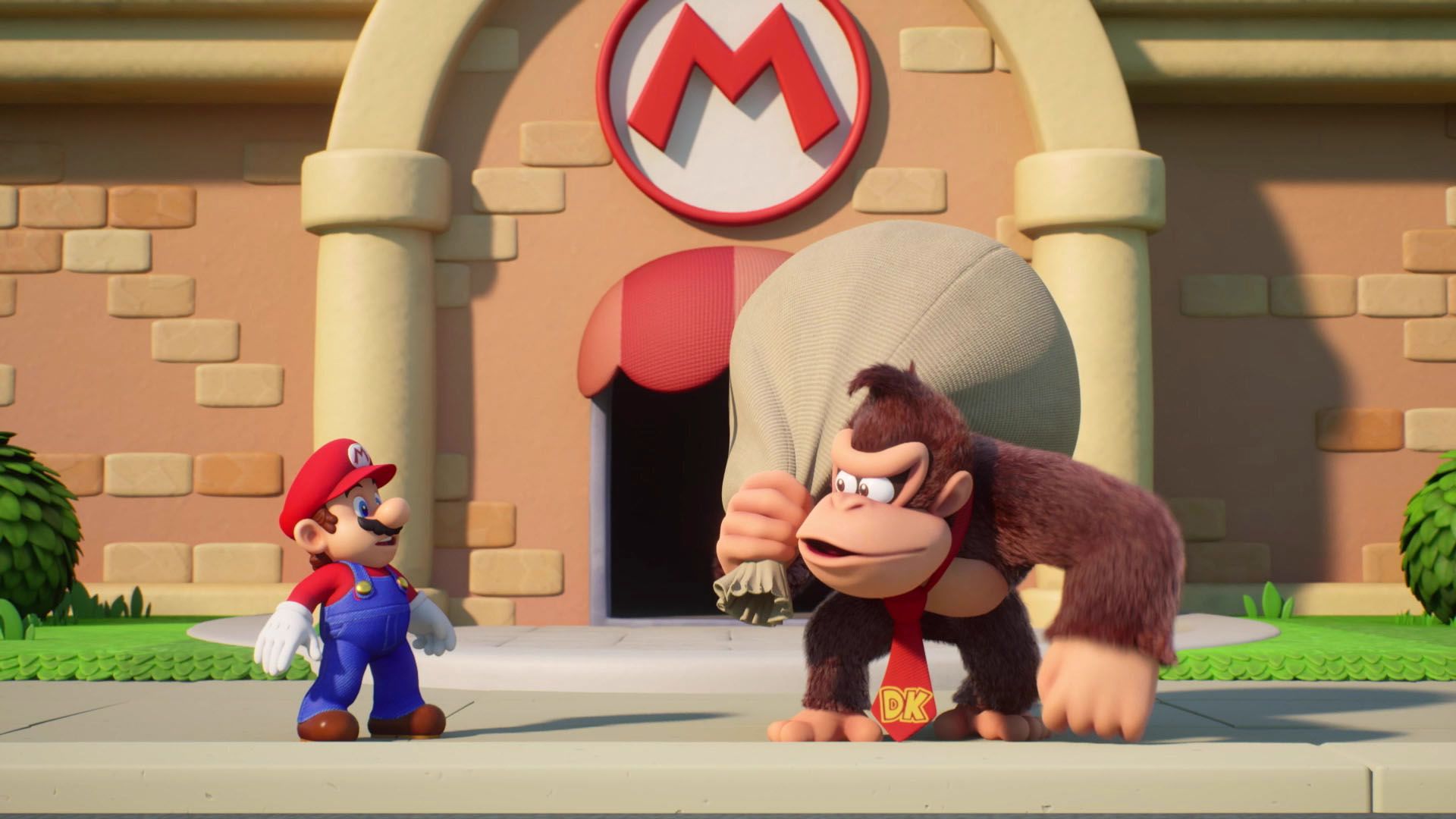 Марио задумчиво смотрит на Donkey Kong, у которого на плече висит большой мешок, в то время как он стоит перед зданием с логотипом Марио. Искренне говоря, это выглядит так, будто Donkey Kong только что ограбил Марио. Это скриншот из игры Mario против Donkey Kong.