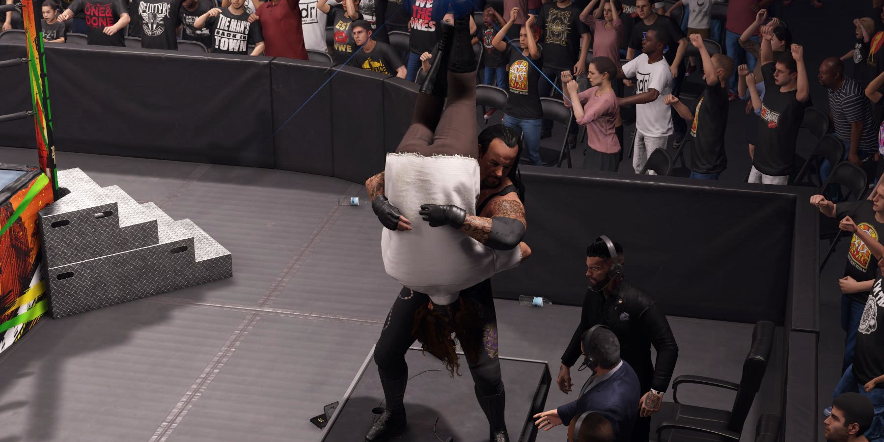 WWE 2K24 Undertaker Tombstoning Mankind through the announcer's desk