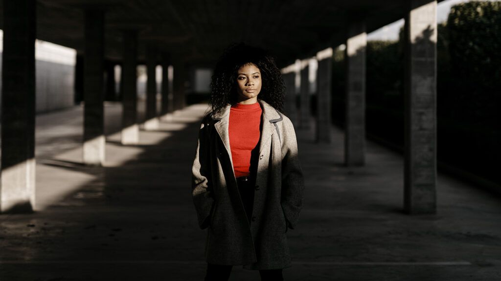 Une jeune femme africaine-américaine se promène le long d'un passage souterrain