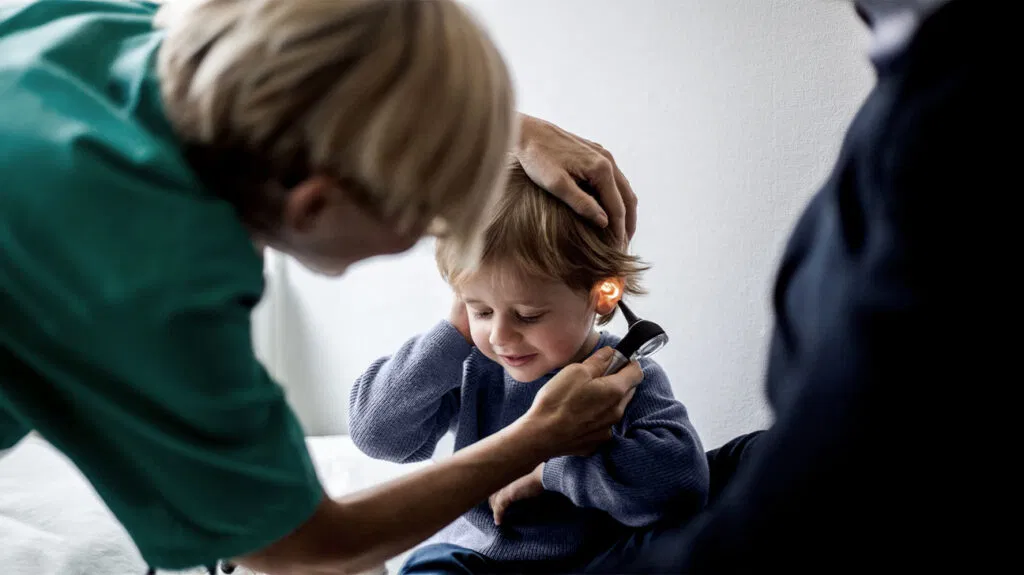 Un medico controlla l'orecchio di un bambino piccolo