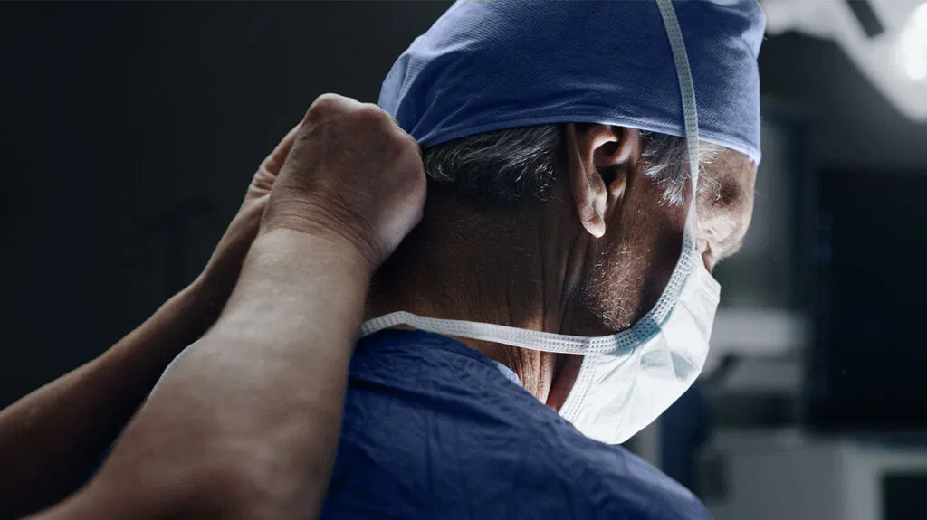 Un assistente medico mette una maschera su un chirurgo