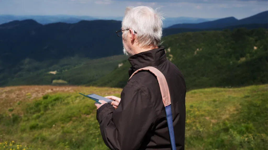 Un uomo anziano si ferma durante un'escursione per ammirare il panorama