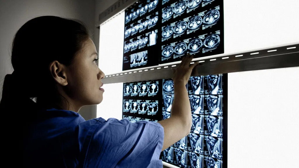 Un technicien regarde un mur d'images de scans cérébraux