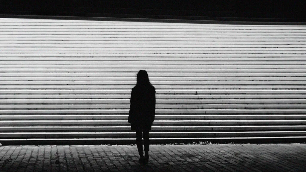 La silhouette di una donna vicino a dei gradini di cemento
