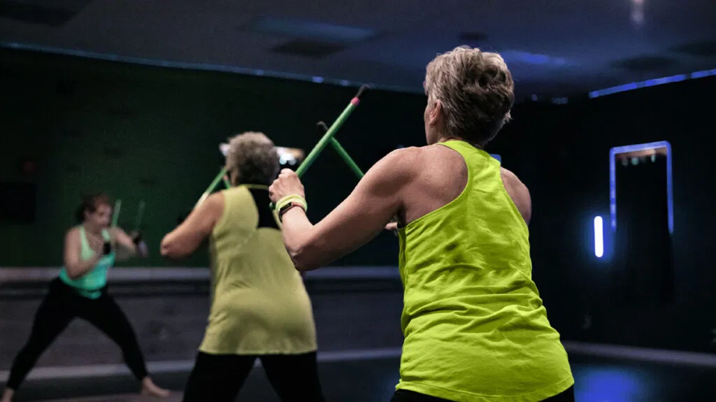 persona anziana che indossa una maglietta verde neon mentre fa esercizi in palestra