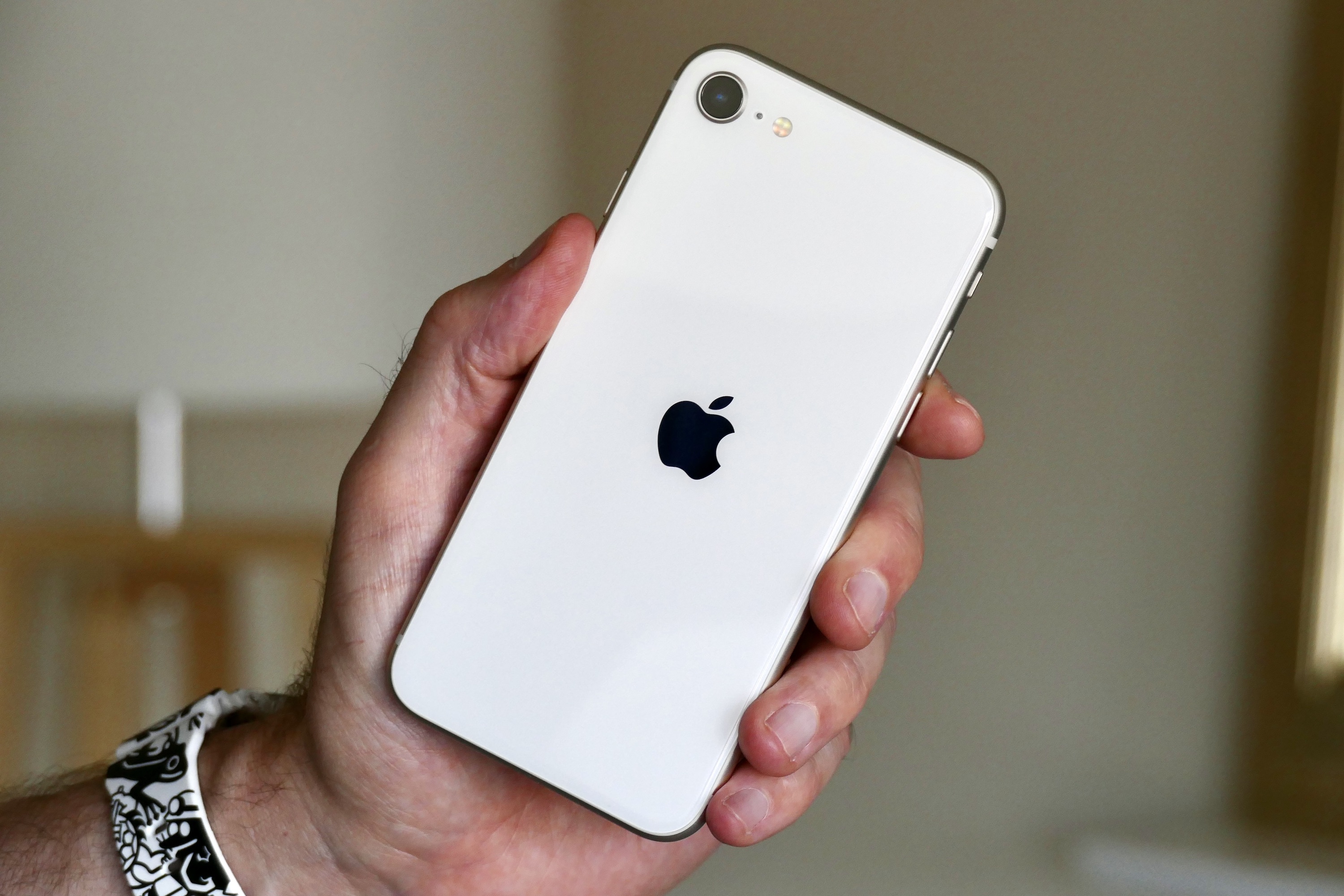 El Apple iPhone SE (2022) sostenido en la mano de un hombre.
