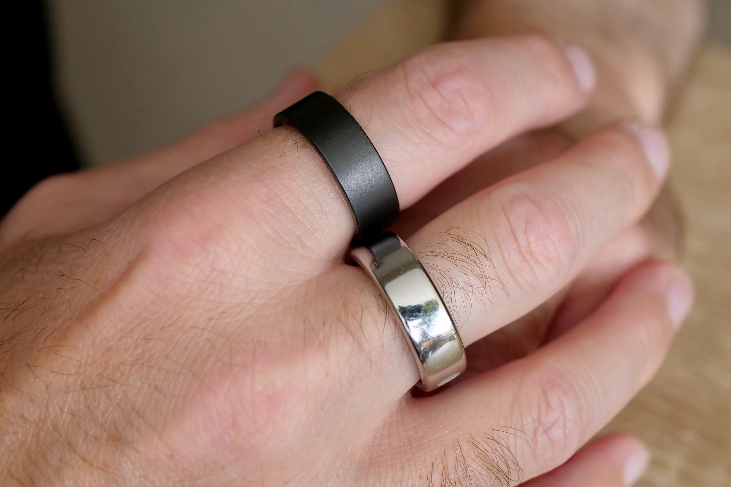 A person wearing the Ultrahuman Ring Air and the Oura Ring