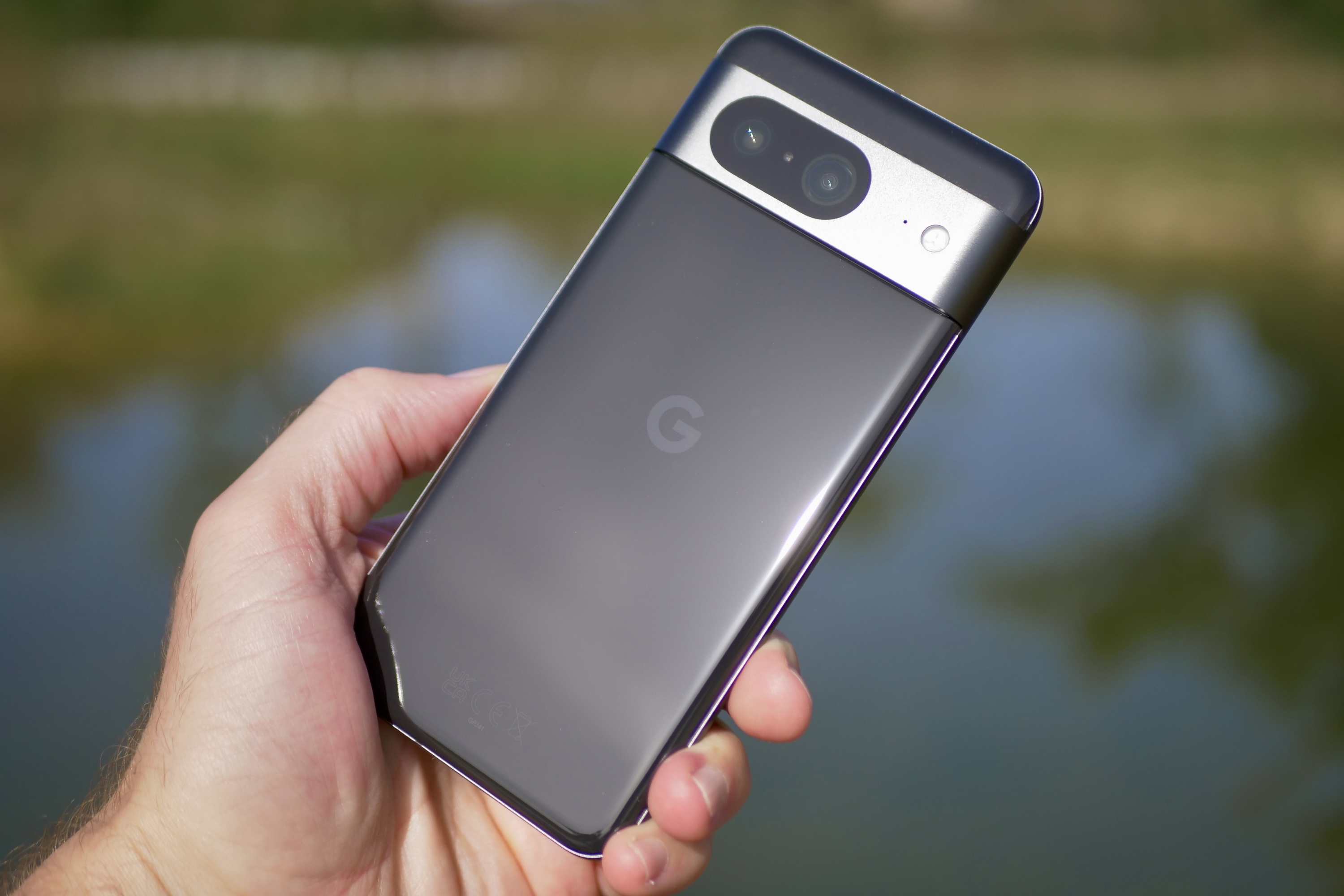 Человек держит Google Pixel 8, показывая заднюю часть телефона.