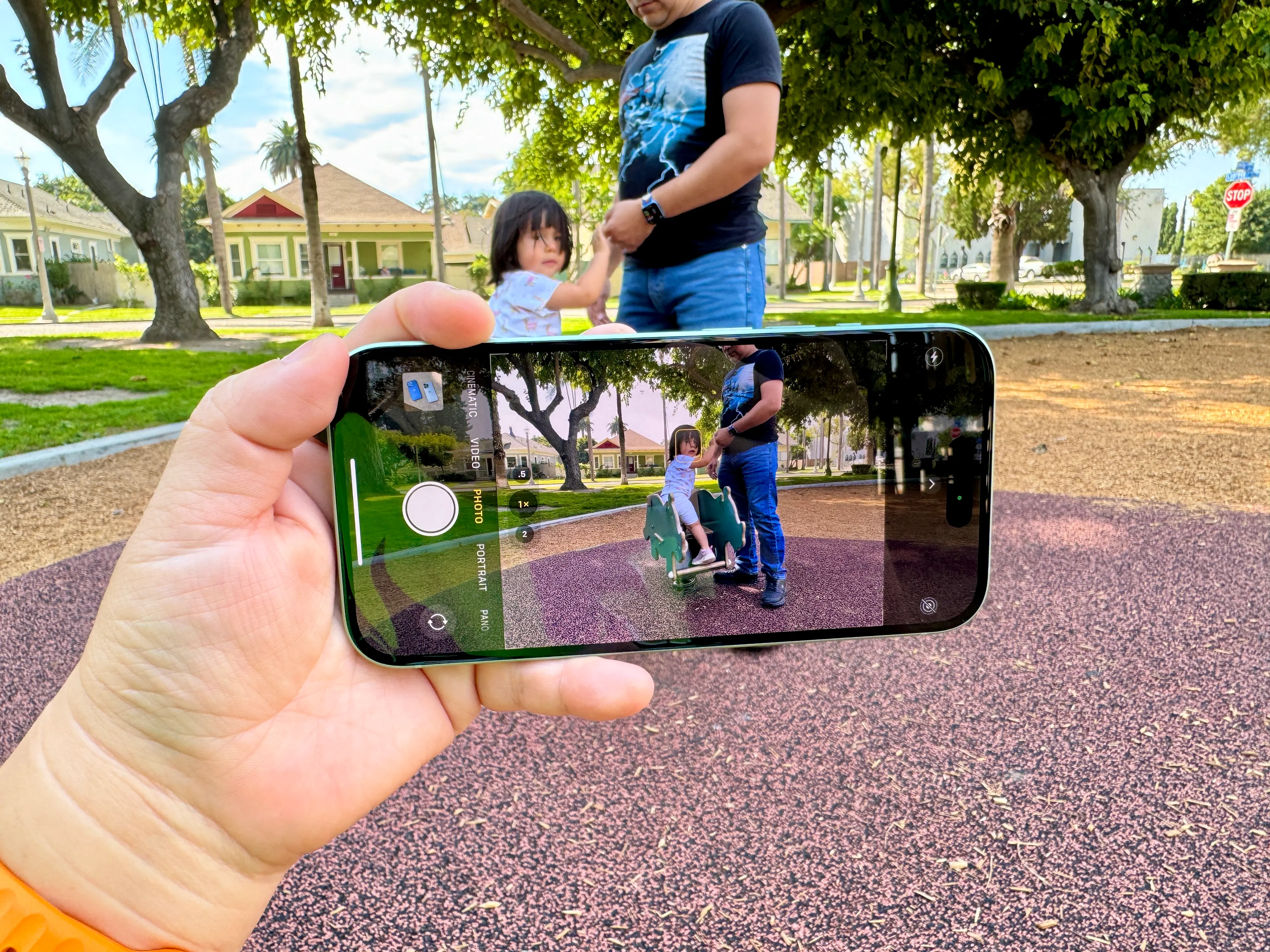 Um iPhone 15 verde usando a câmera na orientação paisagem.