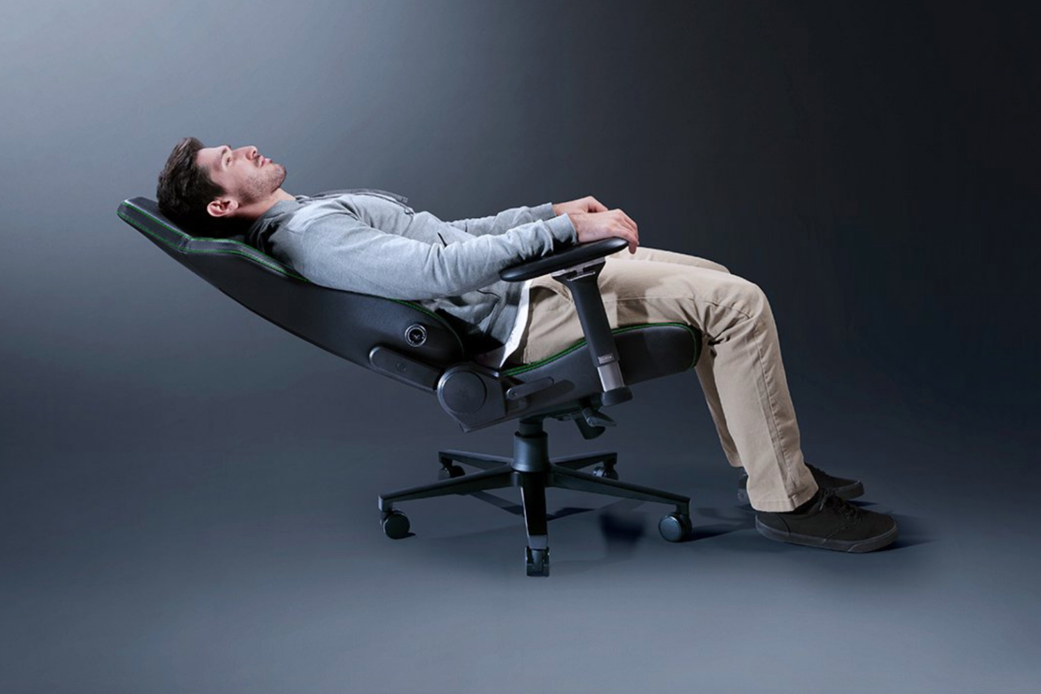 A model laying reclined on the Razer Izkur V2 gaming chair