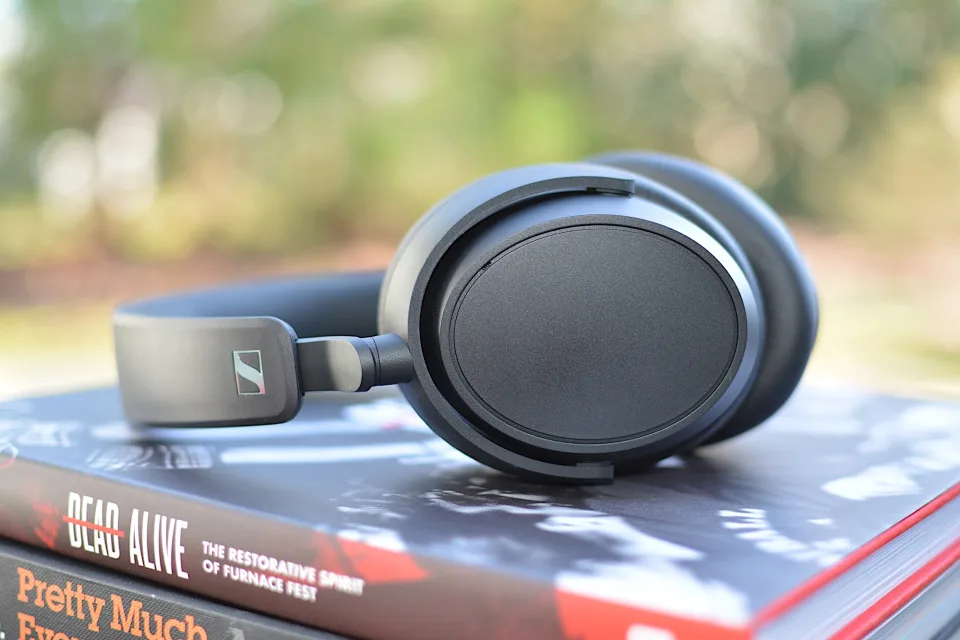 Sennheiser Accentum Plus headphones from the side, laid flat on two books.