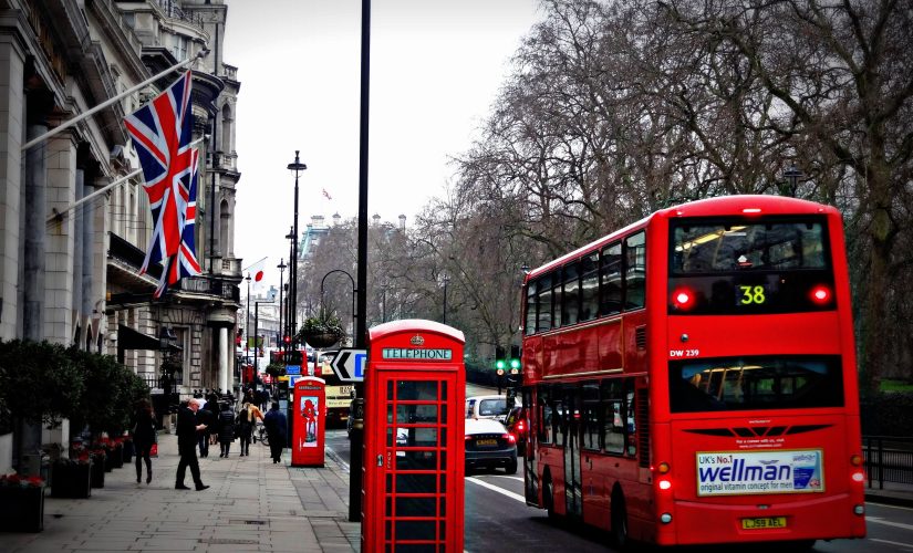 Изображение автобусов Лондона и красного телефонного будки на улице Лондона