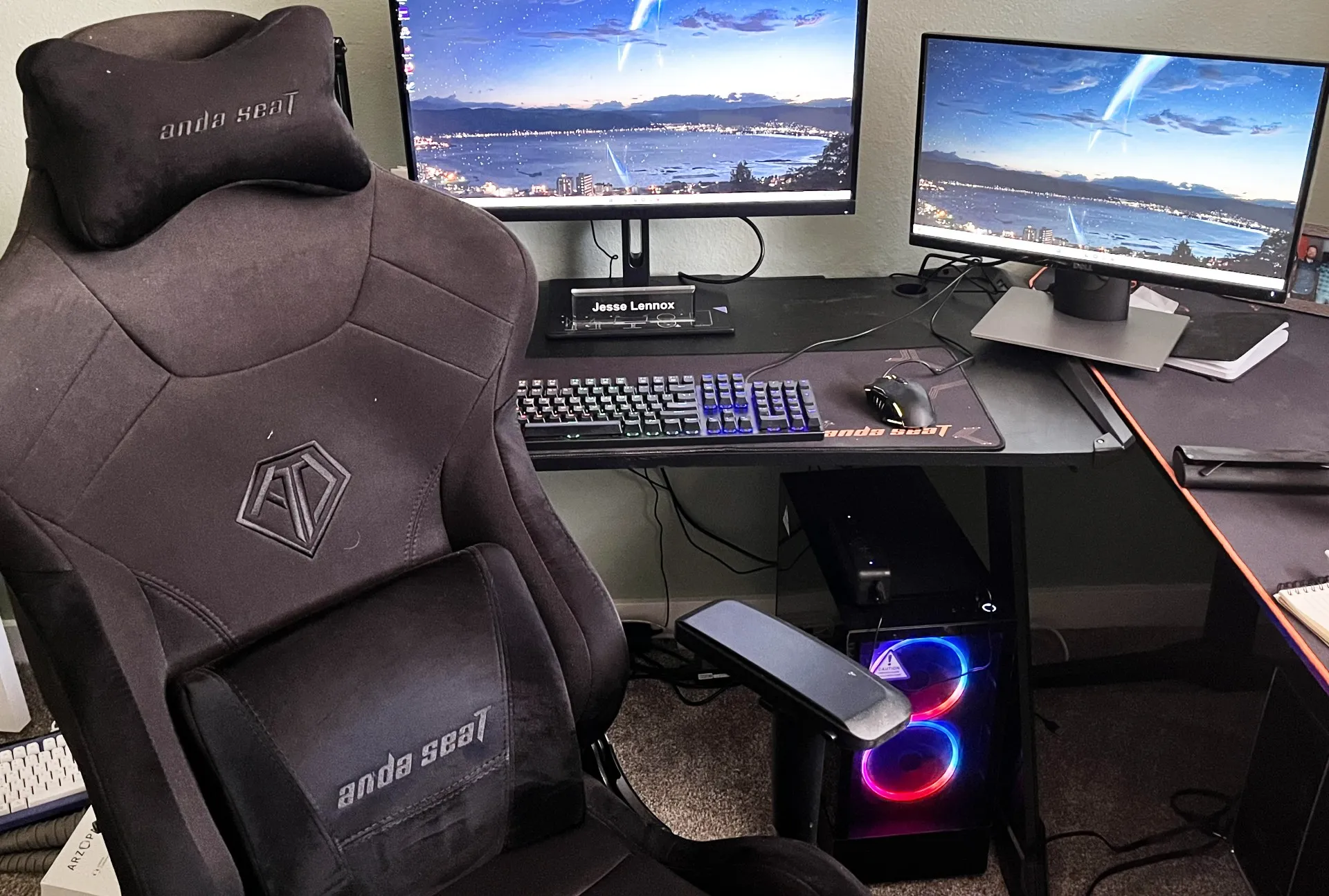 Un setup desktop per PC gaming con due monitor e una sedia da gaming.