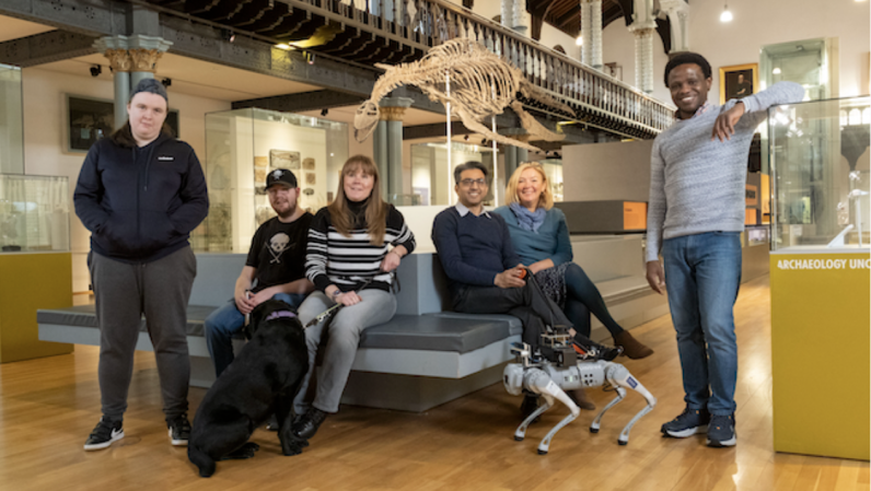 Equipe do RoboGuide no museu Hunterian com cão guia vivo e o cão guia robótico