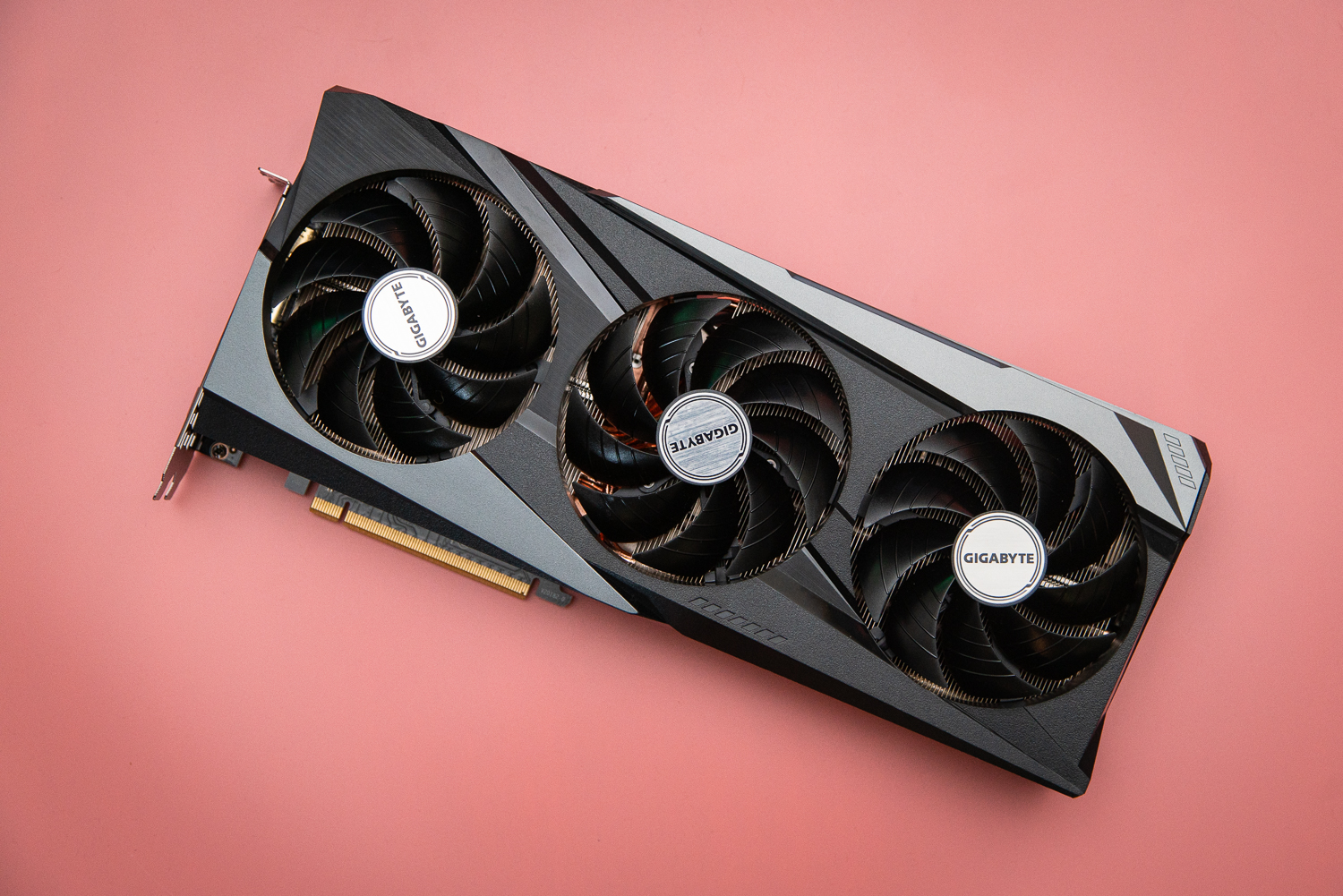 Scheda grafica AMD RX 6950 XT su uno sfondo rosa.