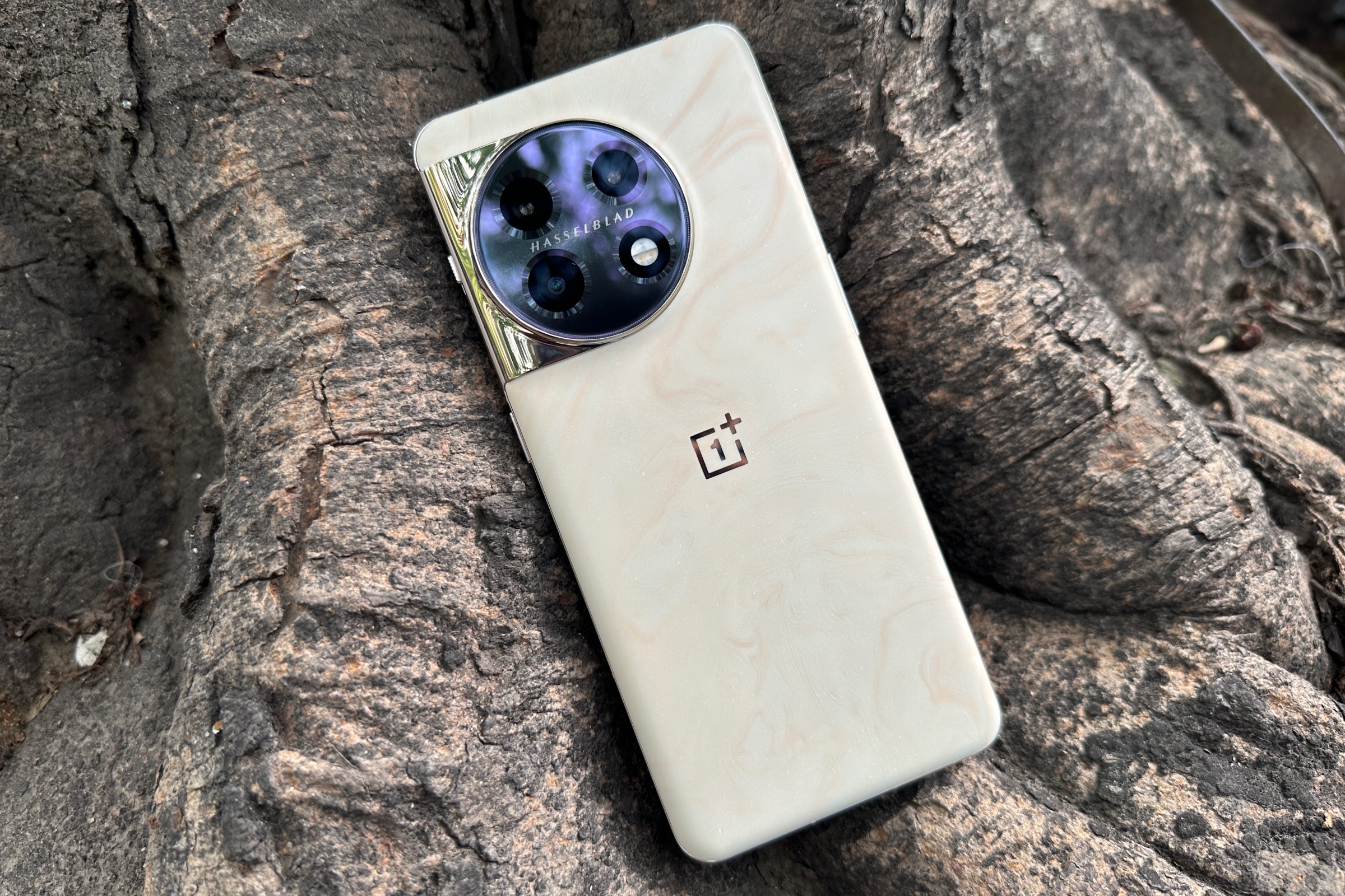 OnePlus 11 Marble Odyssey Edition reclining against a tree