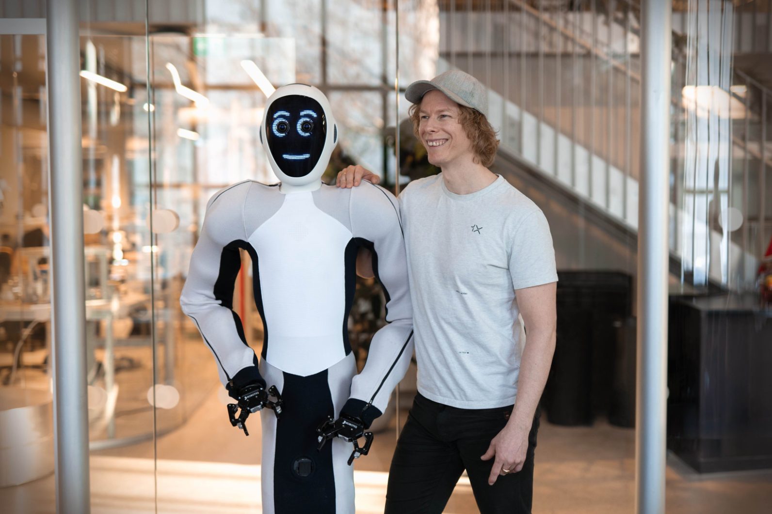 CEO di 1X Bernt Øivind Børnic con il braccio attorno all'umanoide Eve.