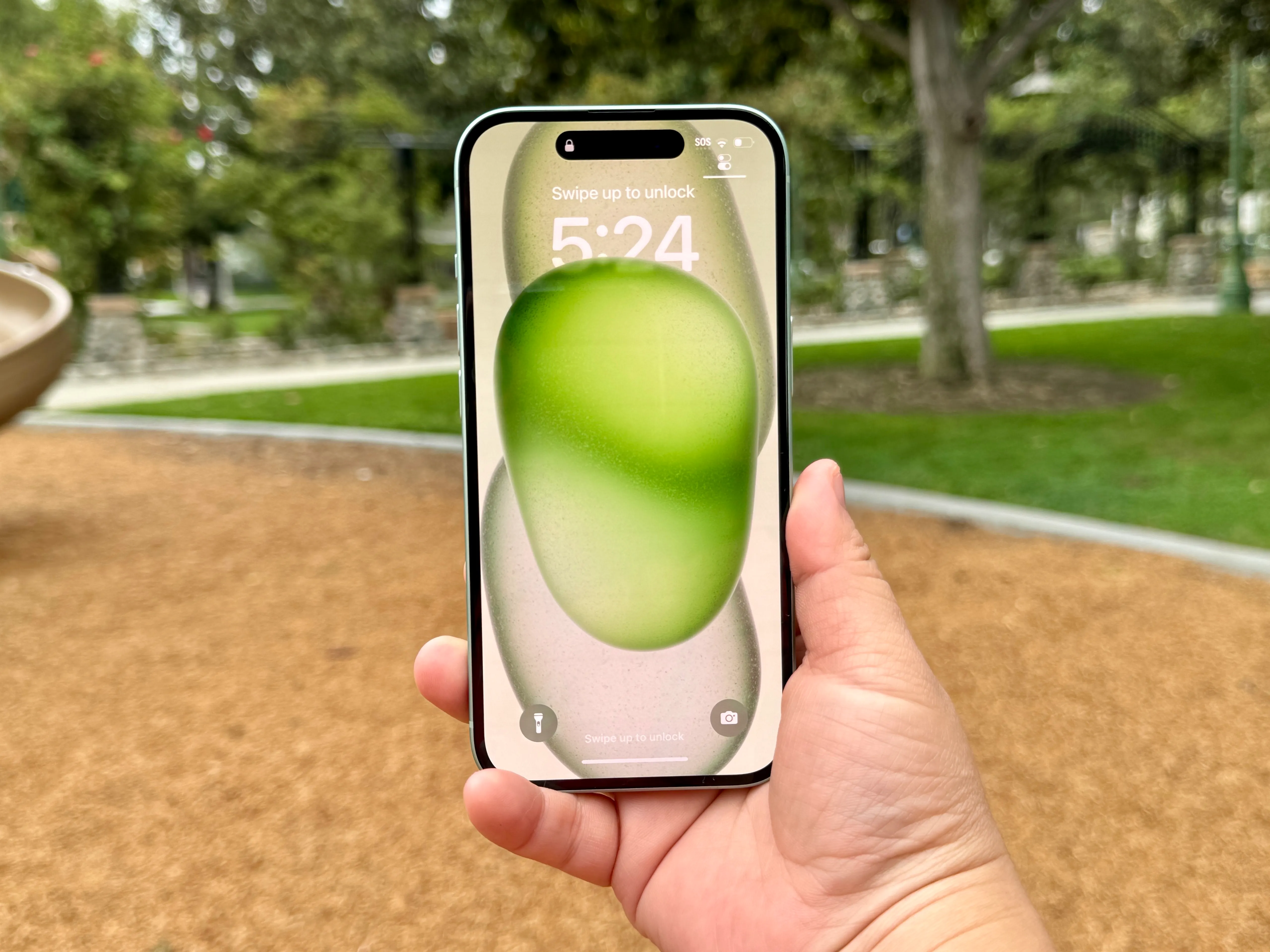 Uma tela de bloqueio verde do iPhone 15.