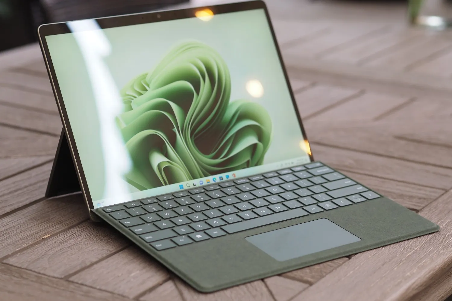 O Surface Pro 9 verde aberto no chão.