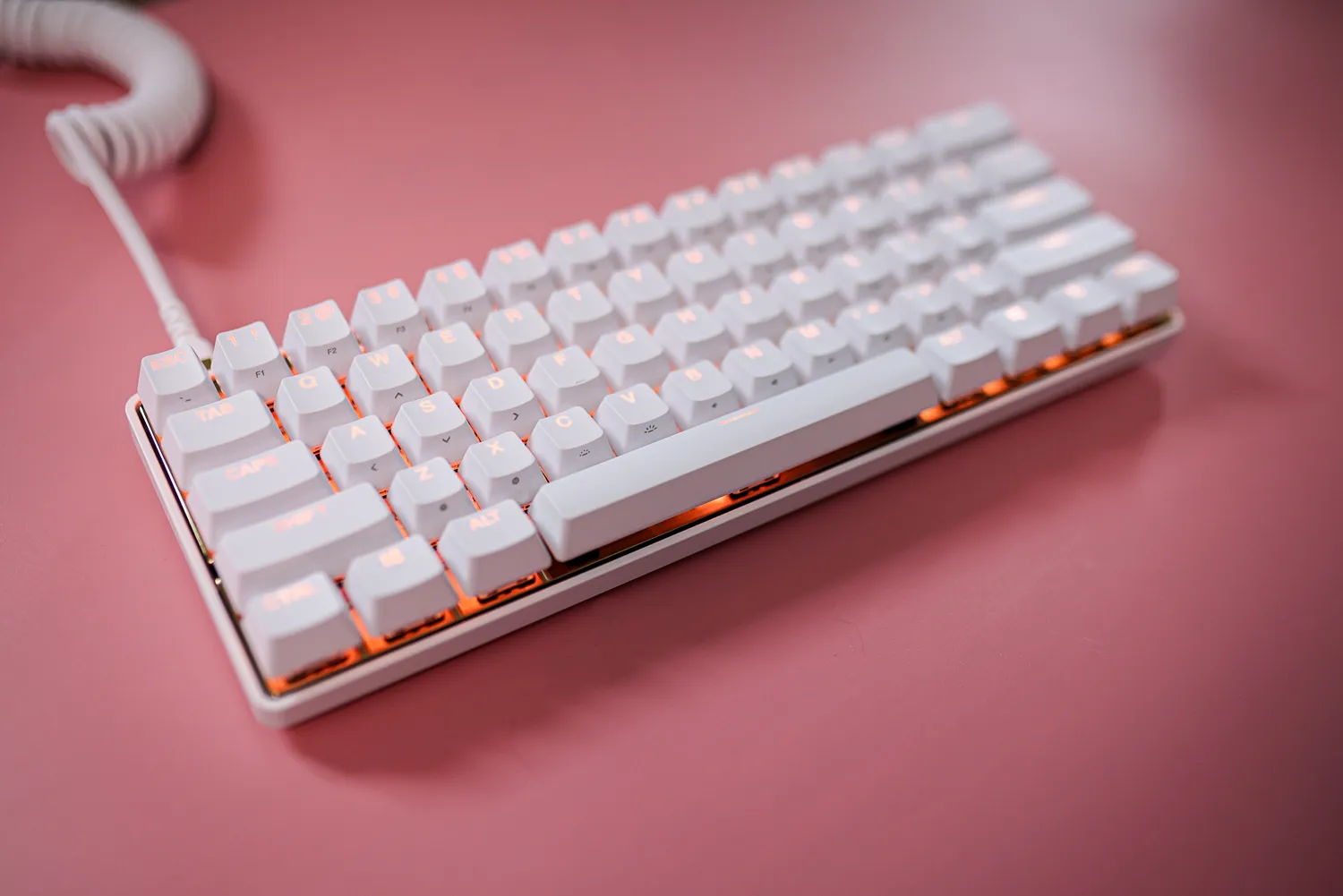 La tastiera Steelseries White Gold su uno sfondo rosa.