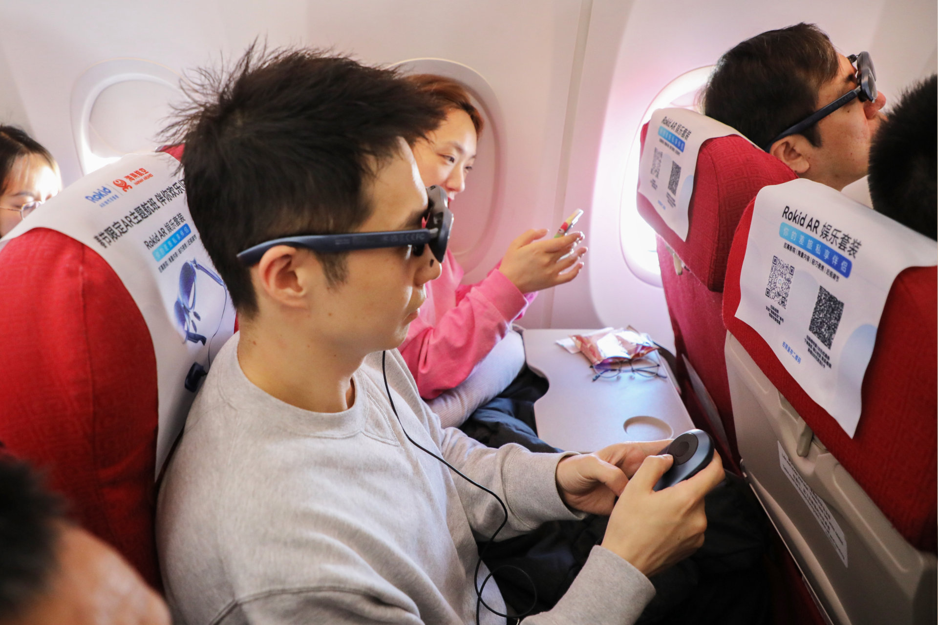 Gli occhiali intelligenti Rokid Max e la stazione Rokid sono mostrati in uso su un volo di Hainan Airlines.
