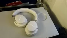 Bose QuietComfort Ultra headphones on an airplane seat back tray