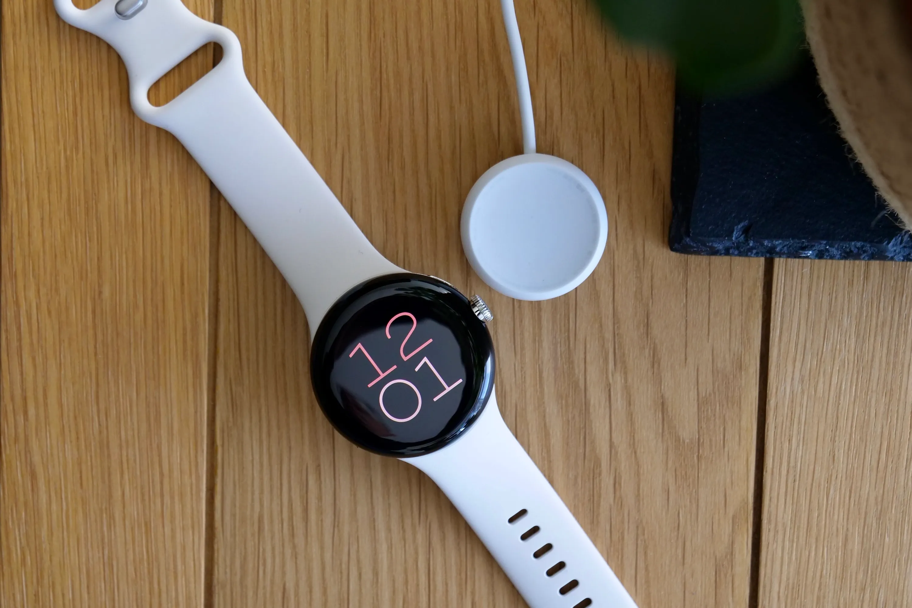 Google Pixel Watch с его зарядным устройством.